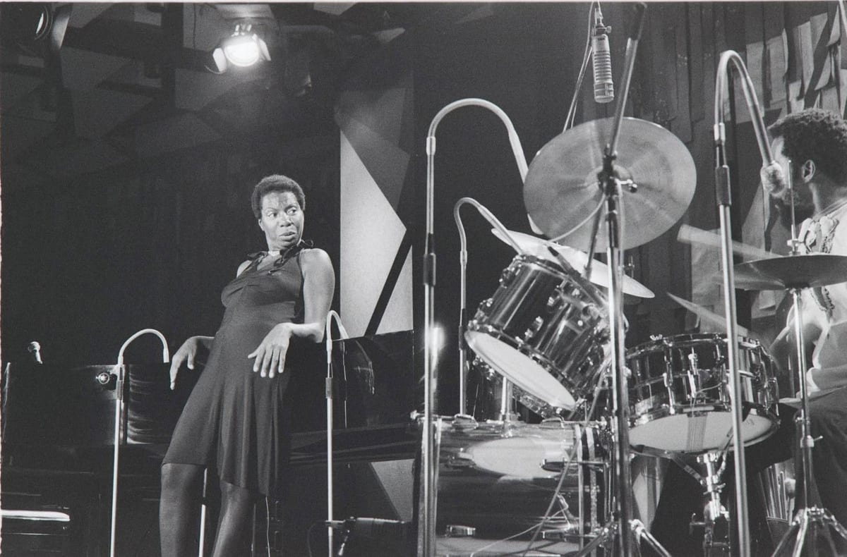 Nina Simone appuyée au piano, pendant le concert de 1976.