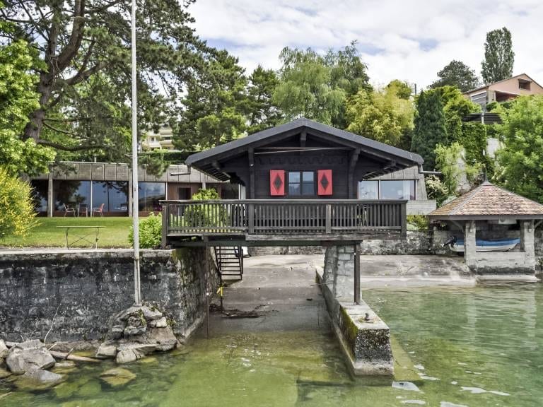 Le chalet de bois sur pilotis, les pieds dans l'eau, avec sa terrasse face au Léman.