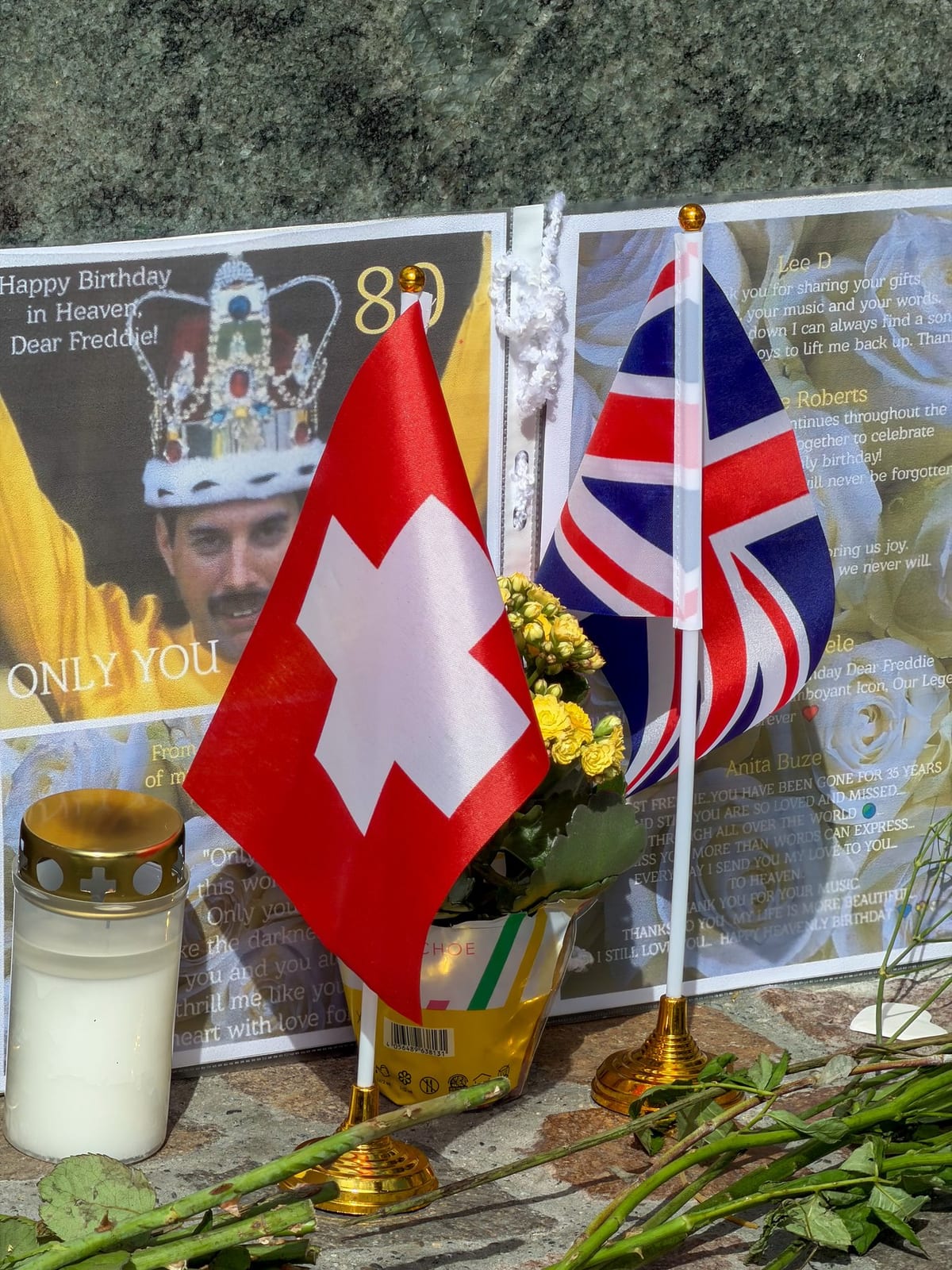 Drapeaux suisse et britannique et bougies au pied de la statue.