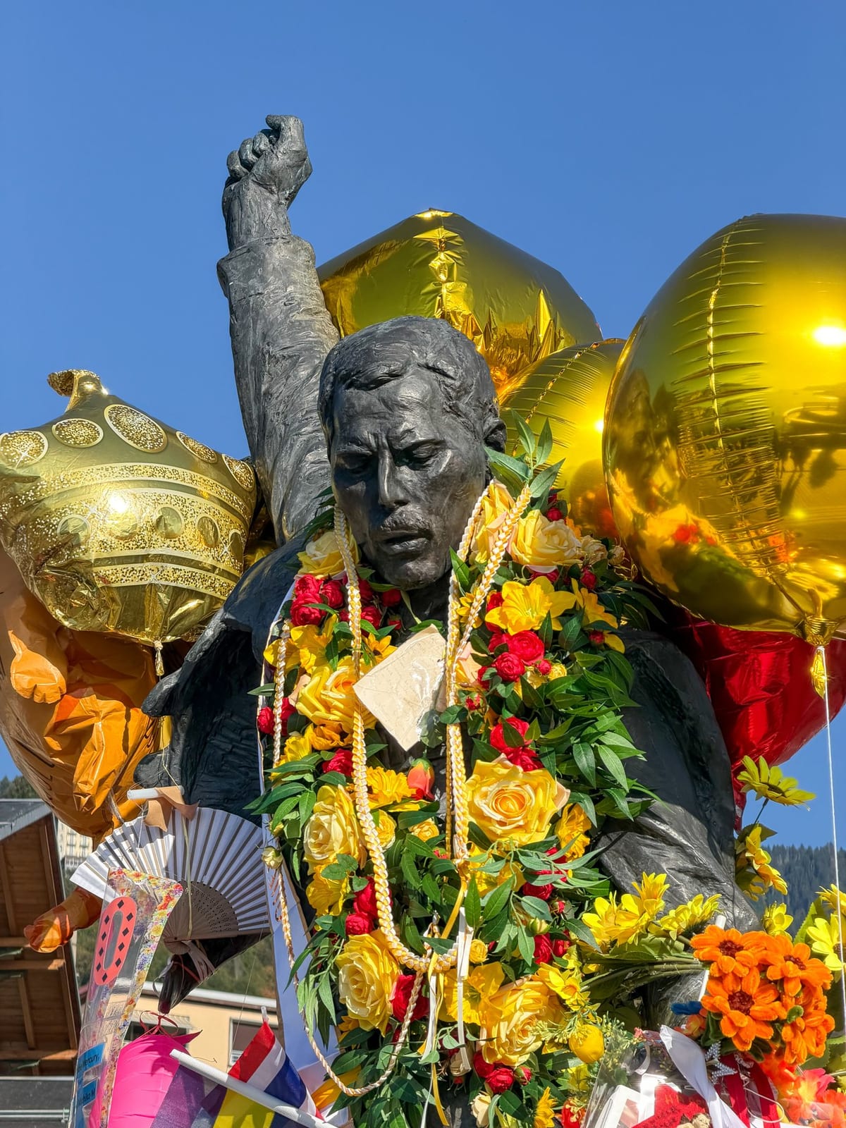 La statue face au lac, entourée de ballons dorés.