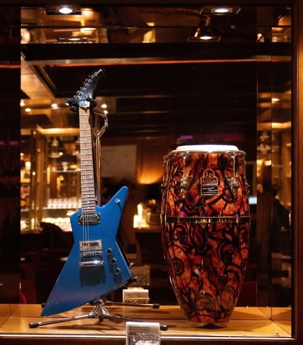 La vitrine d’instruments du Funky Claude’s Bar : une guitare de Lenny Kravitz et une conga de Carlos Santana.