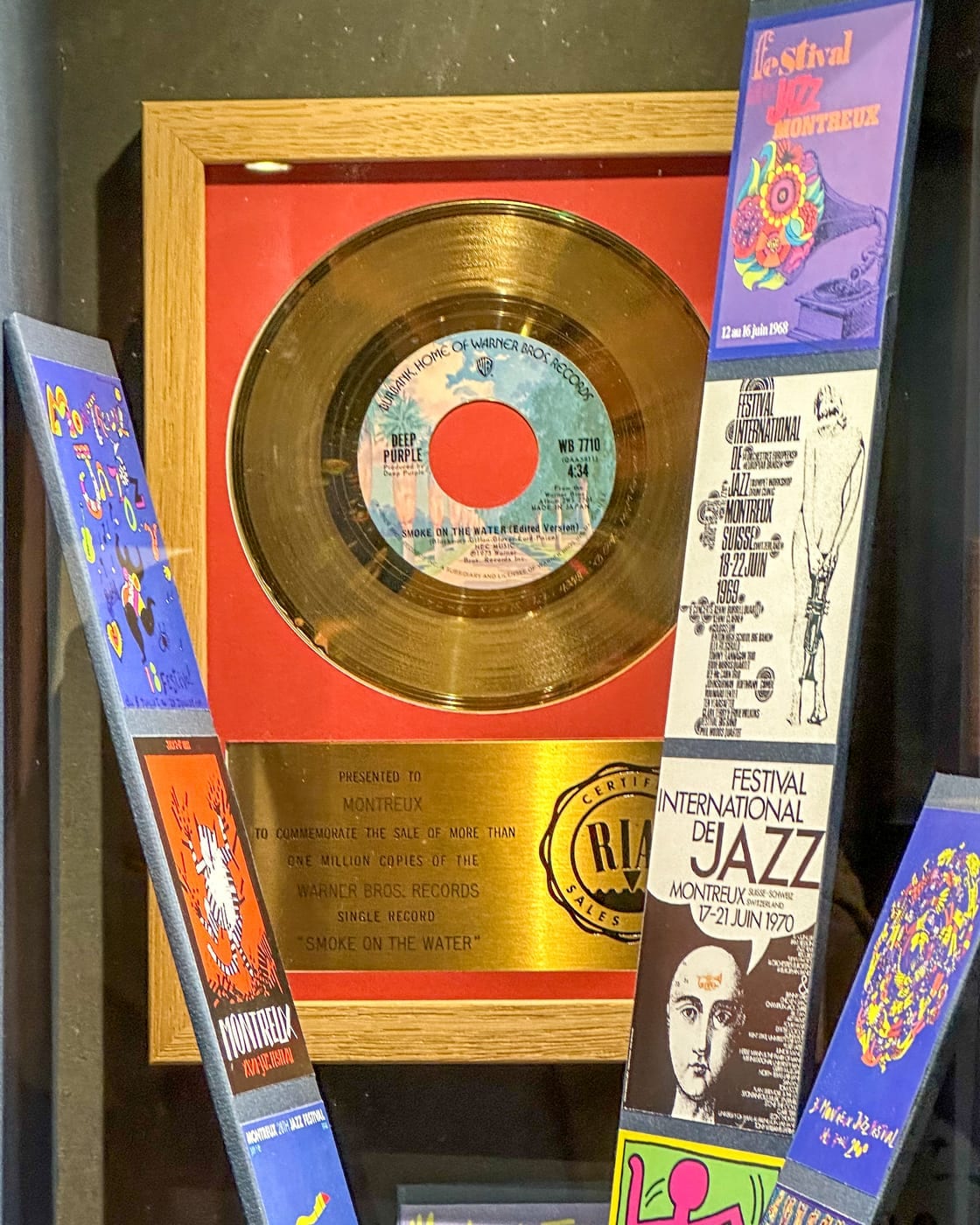 Le disque d’or RIAA remis à Montreux pour le million d’exemplaires vendus du single « Smoke on the Water », entouré d’affiches des premières éditions du festival (1968, 1969, 1970).