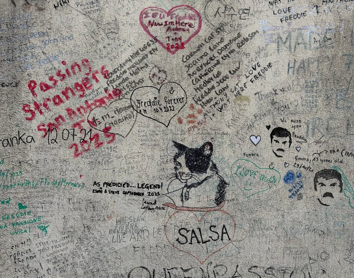 Messages, dessins et signatures laissés par les fans de Queen sur le mur.